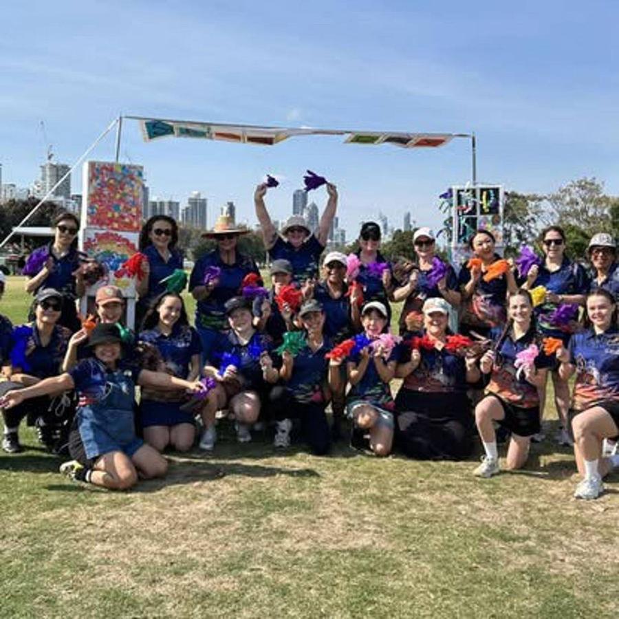 Educators from our three Gold Coast centres together at the annual Family Sports Day, holding up coloured hand puppets